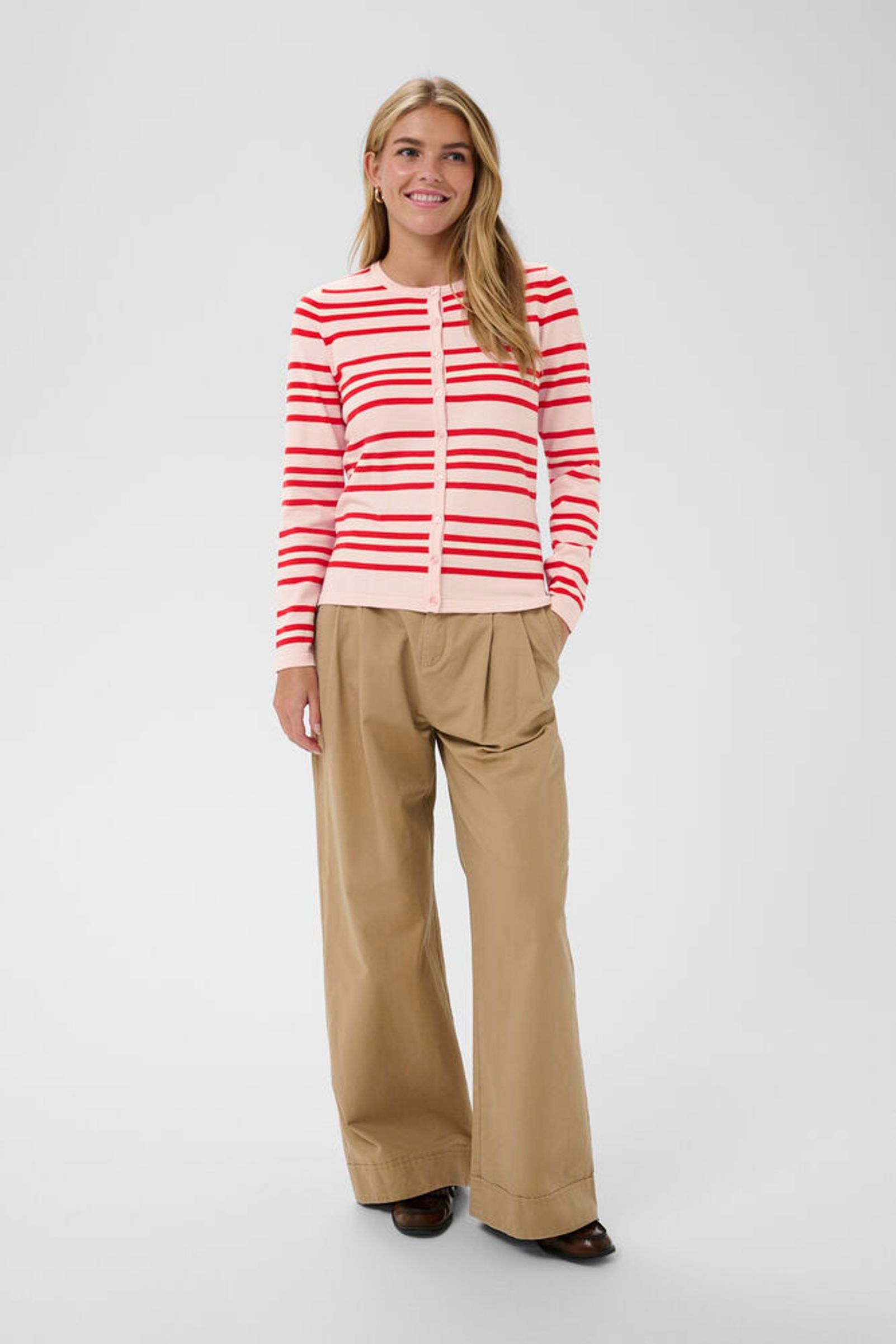 Model wearing pink cardigan with red stripes