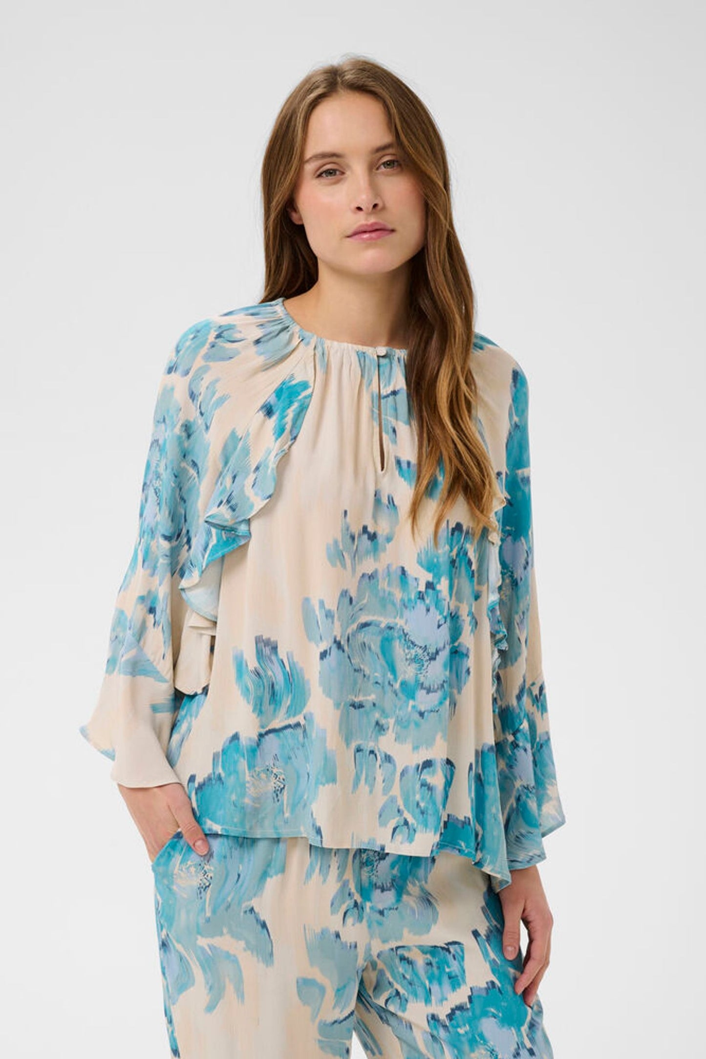 Woman wearing a blue and white floral outfit on a white background