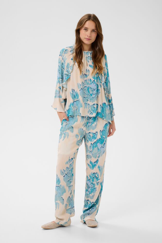 Woman wearing a blue and white floral pajama set on a white background