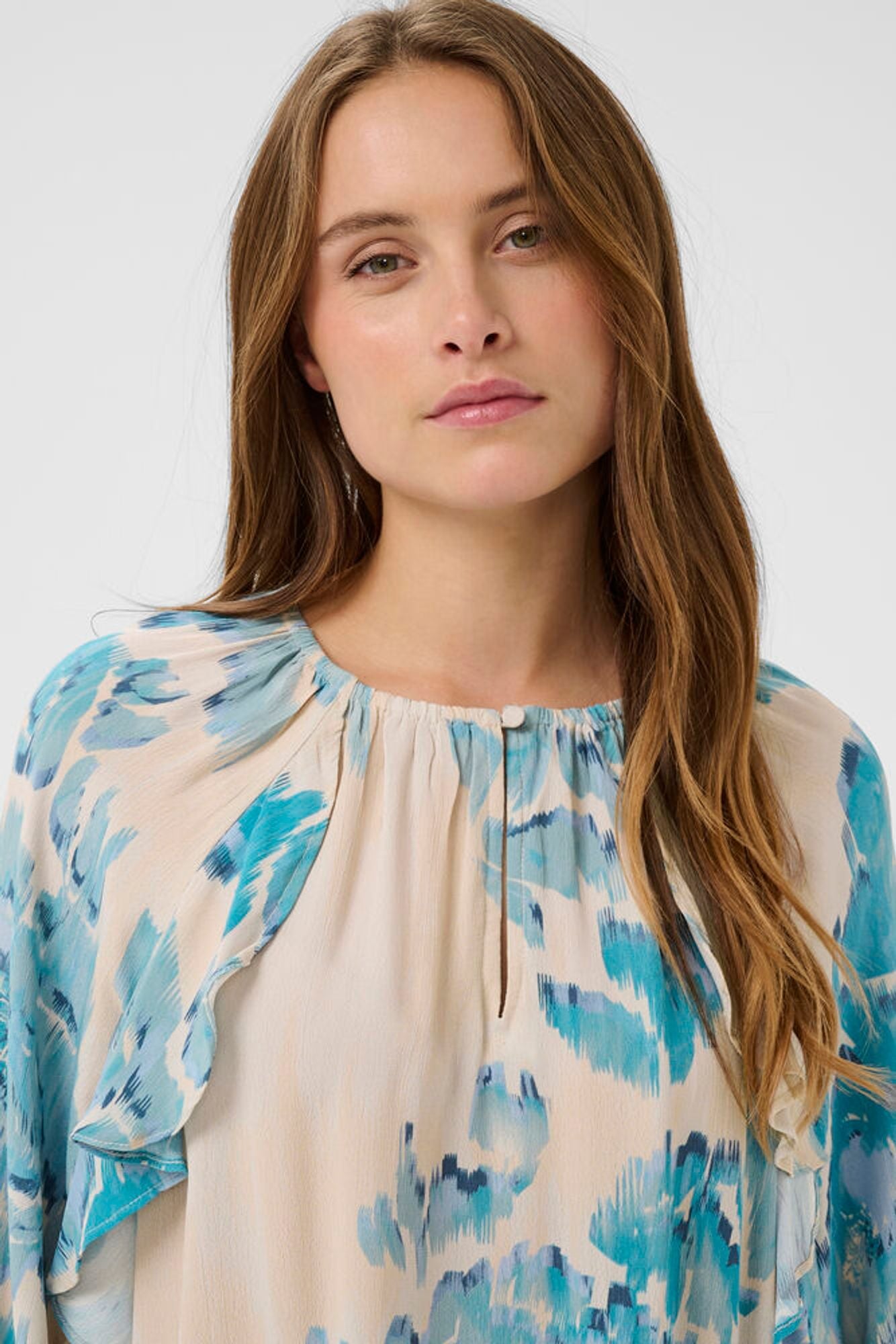 Woman wearing a floral blouse with a plain background