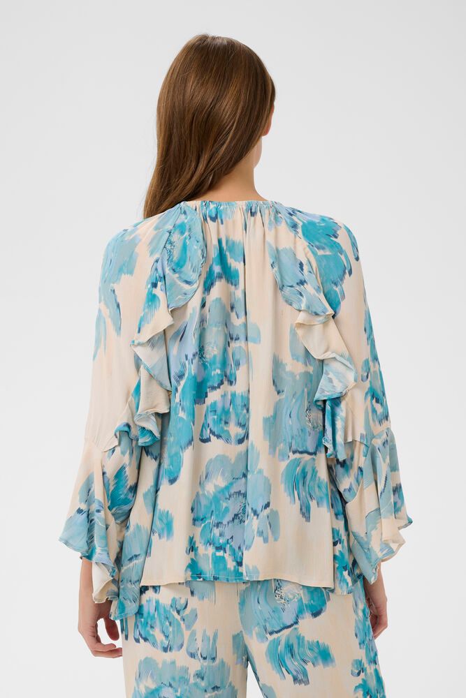 Woman wearing a blue and white floral outfit on a white background