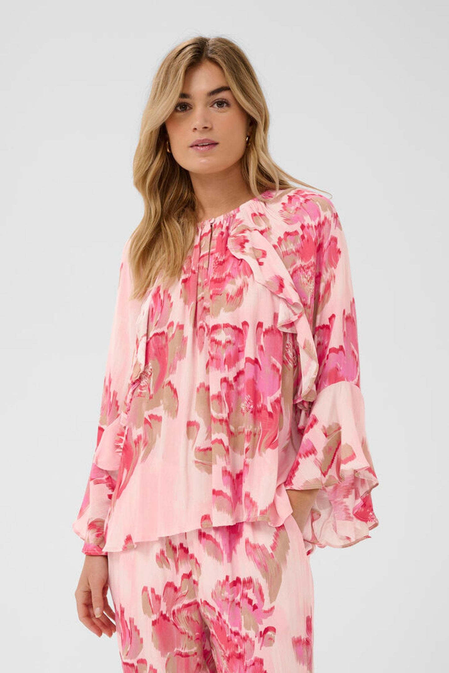 Woman wearing a pink floral blouse on a white background