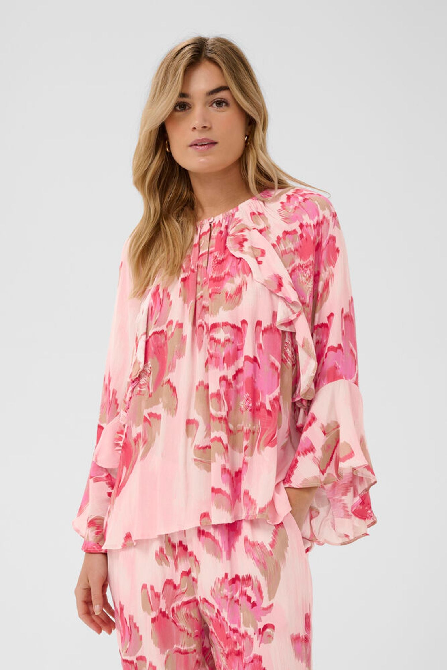 Woman wearing a pink floral blouse on a white background