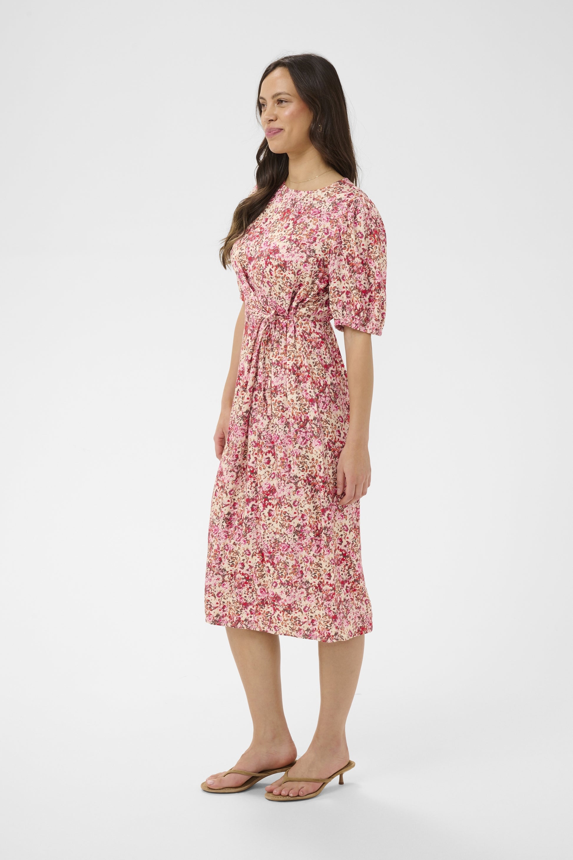 Woman wearing a pink floral dress on a white background