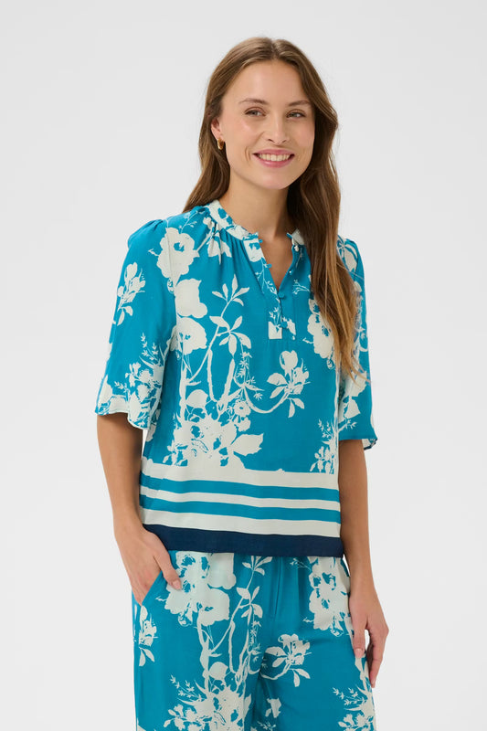 Woman wearing a blue floral outfit on a white background