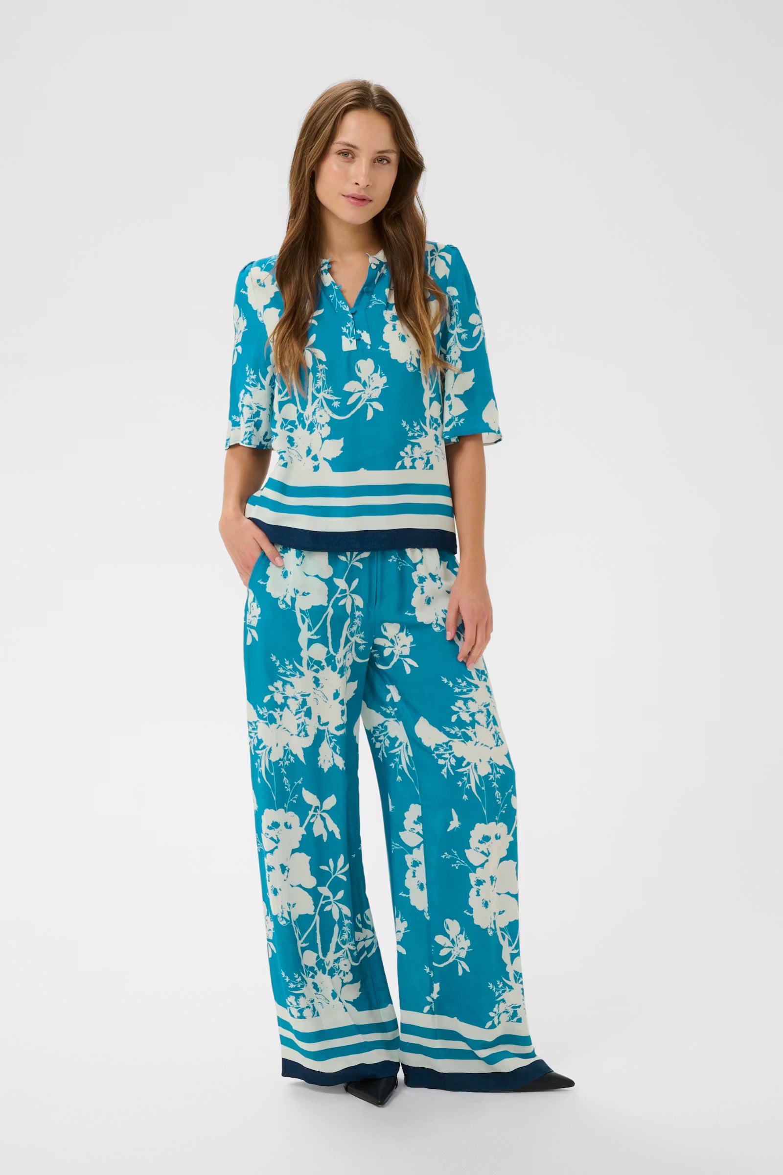Woman wearing a blue floral outfit on a white background