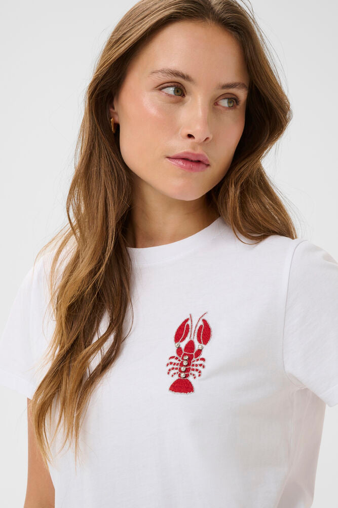 Woman wearing a white t-shirt with a red lobster design on a plain background