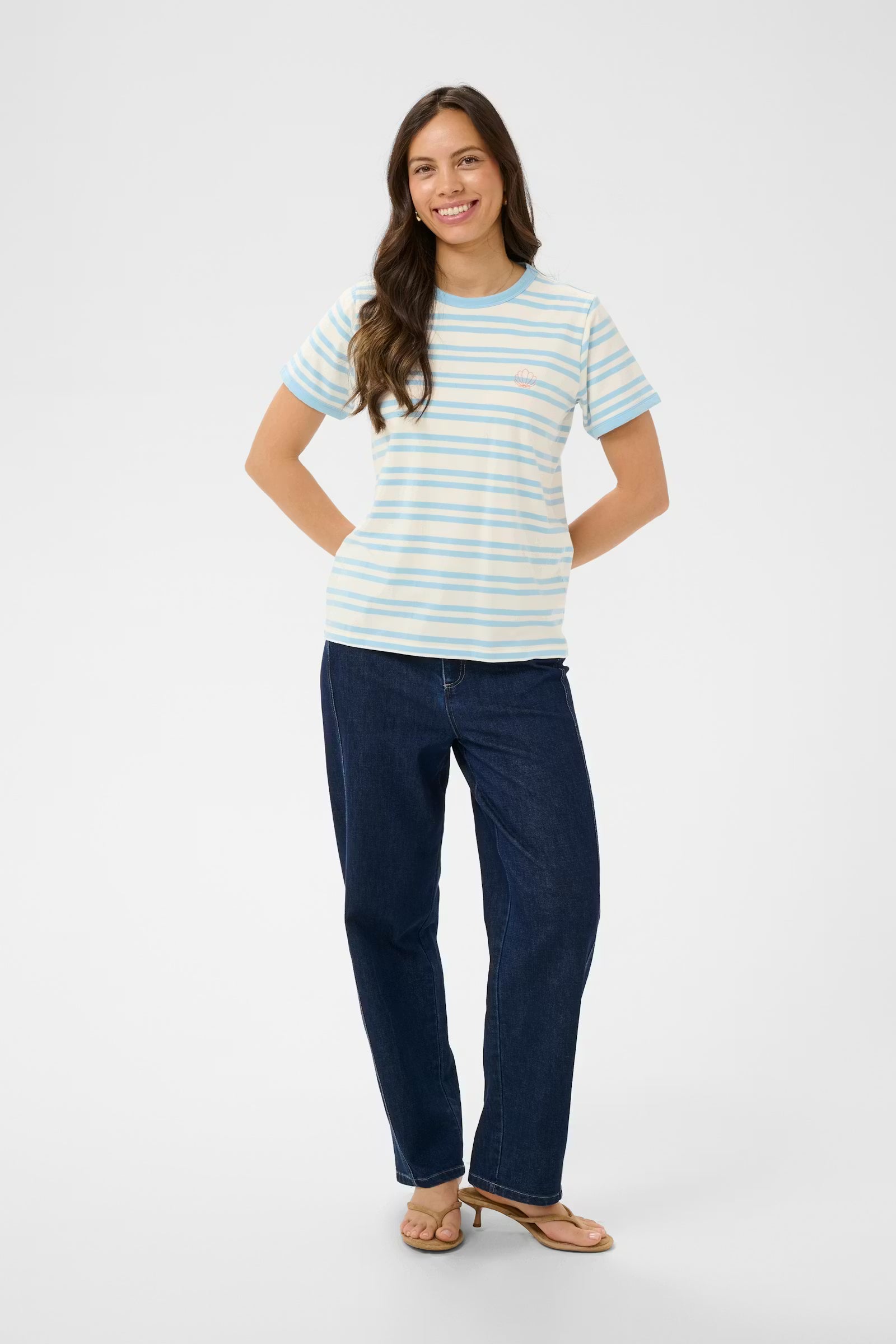 Woman wearing a striped shirt and blue jeans on a white background