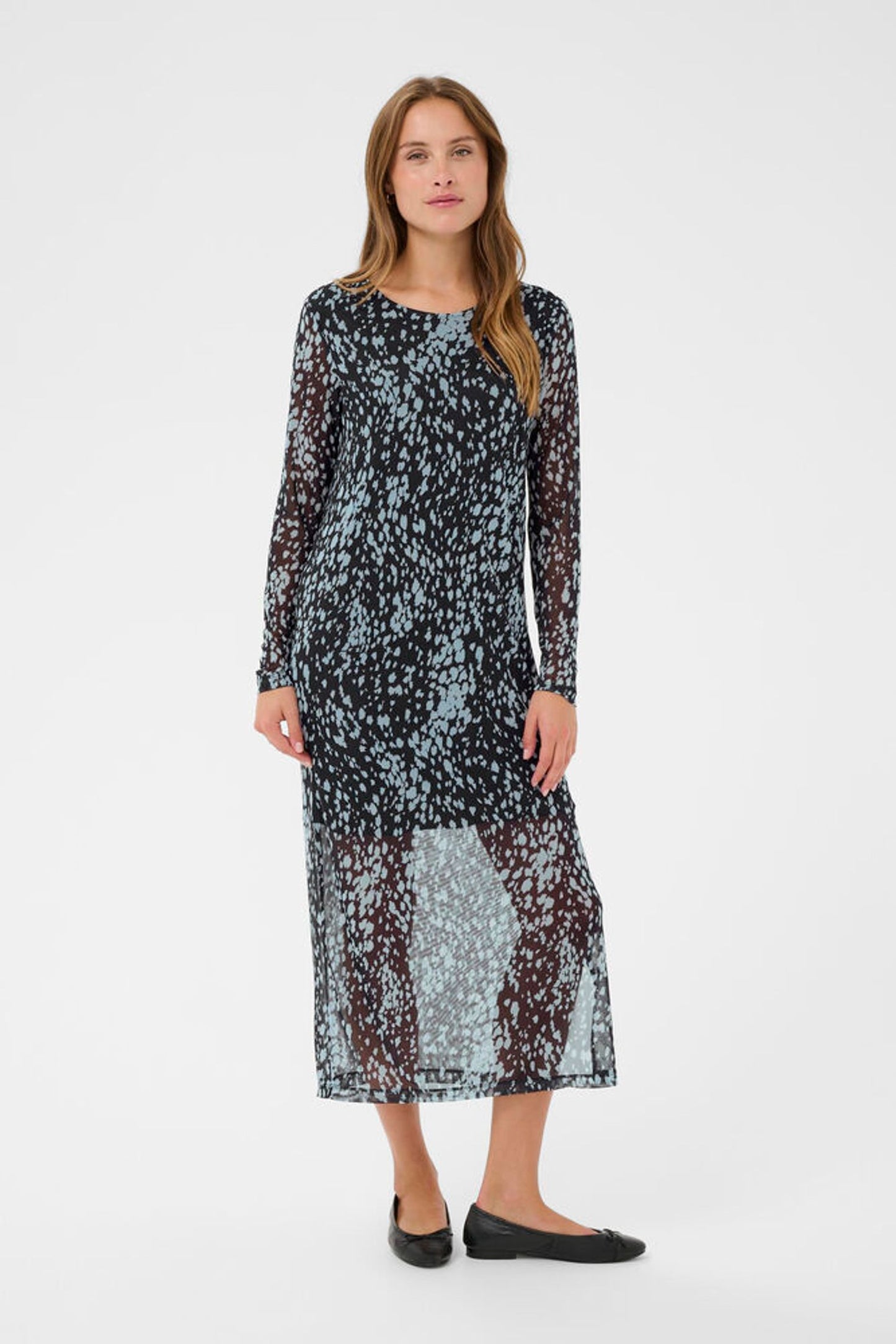 Woman wearing a long, patterned dress on a white background
