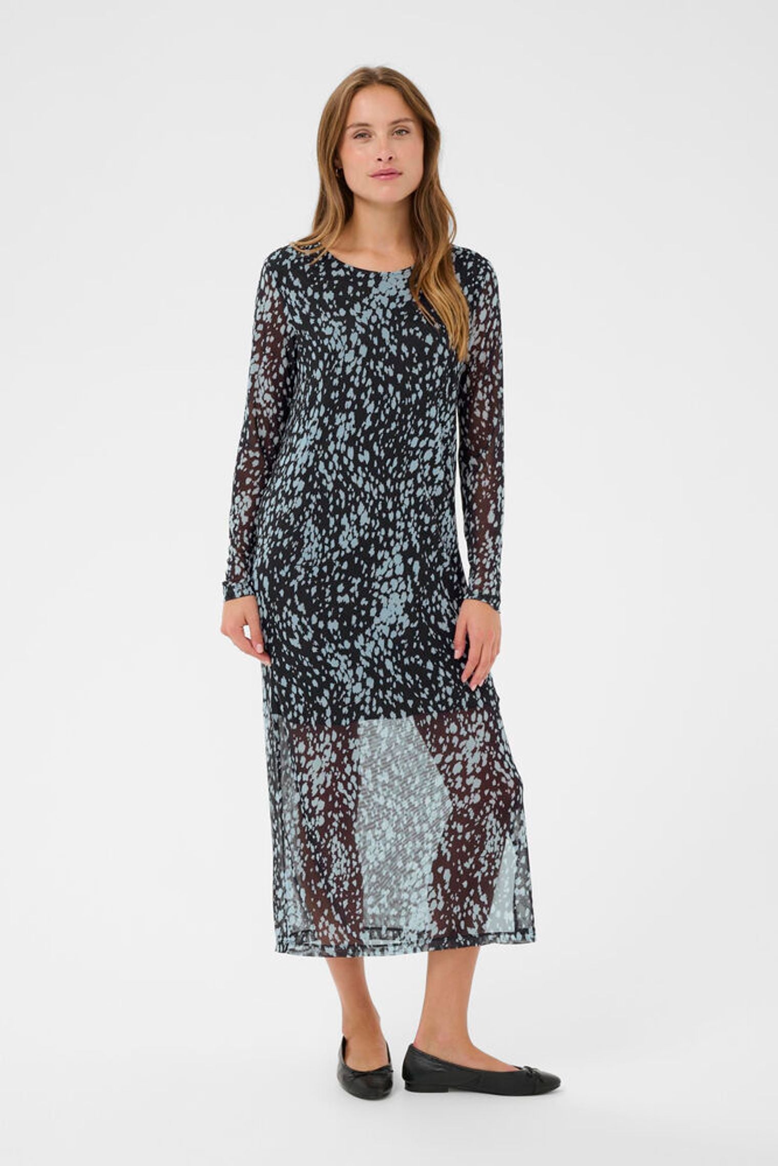 Woman wearing a long, patterned dress on a white background