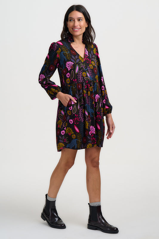 Woman wearing a colorful floral dress on a white background