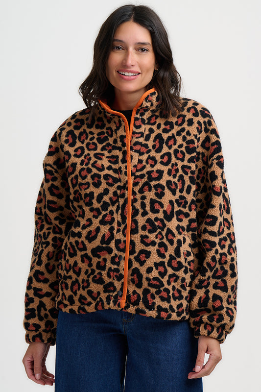 Woman wearing a leopard print jacket with an orange zipper on a white background