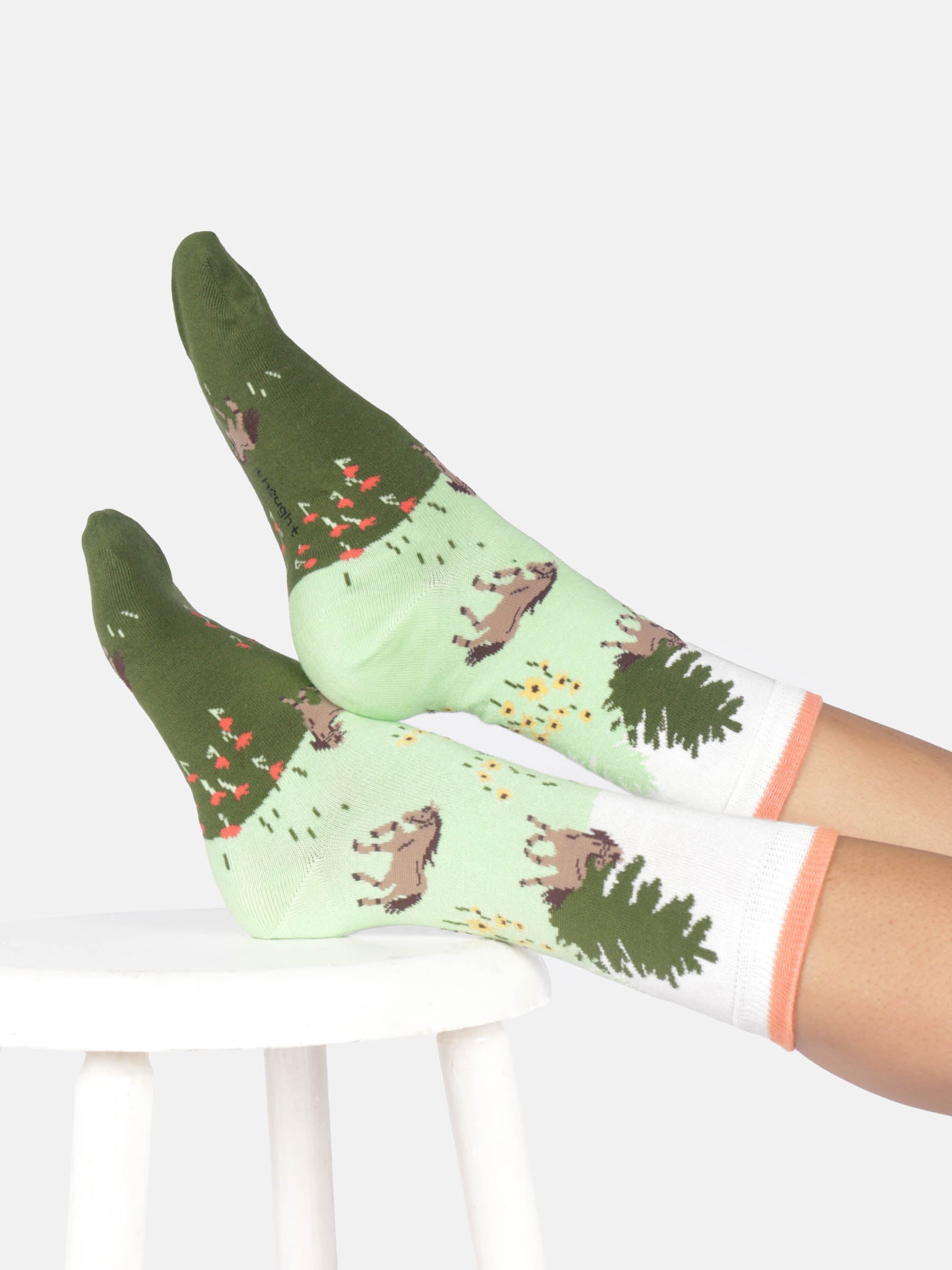 Green and white socks with nature-themed design on a white background