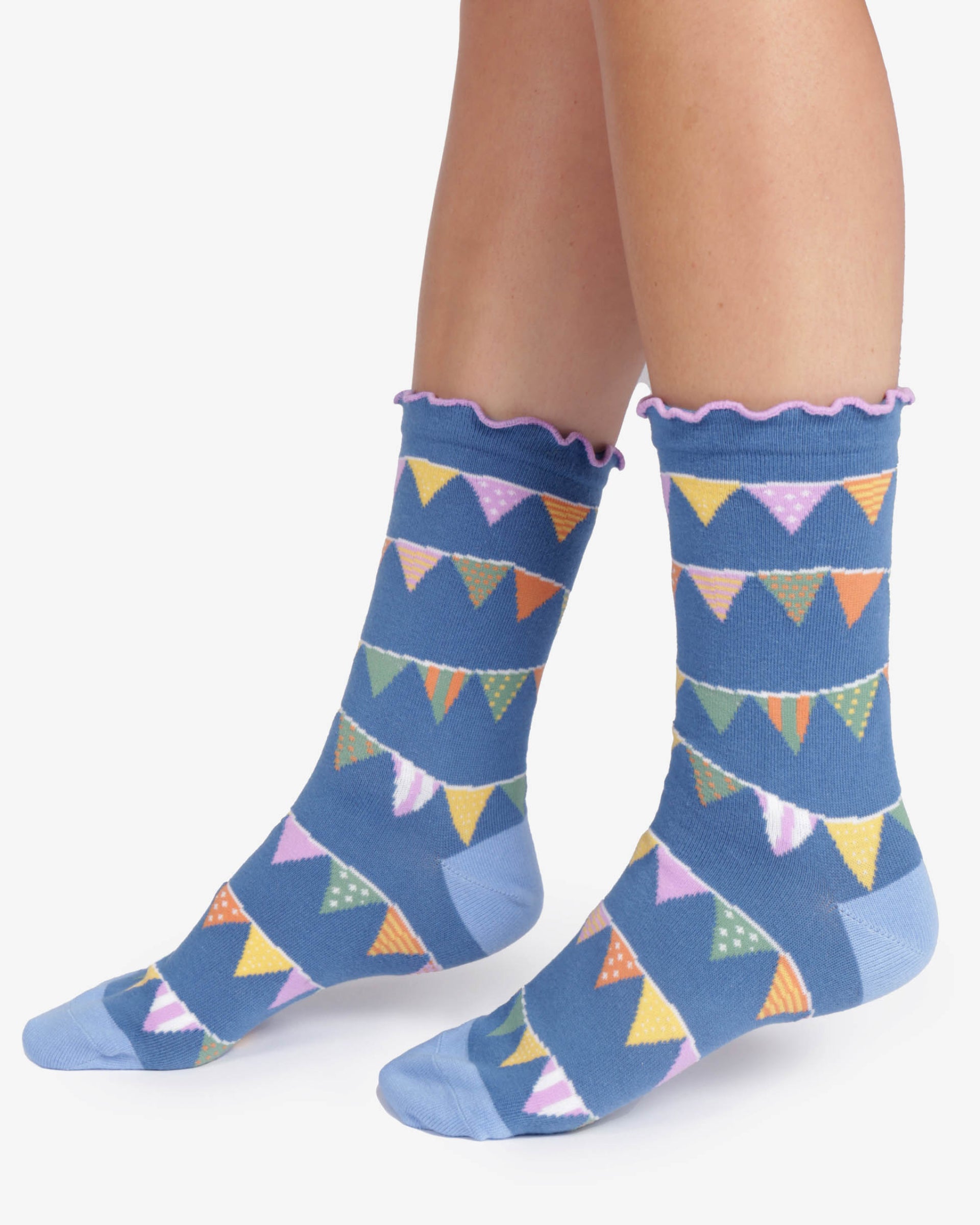 Blue socks with colorful triangle pattern worn by a person on a white background