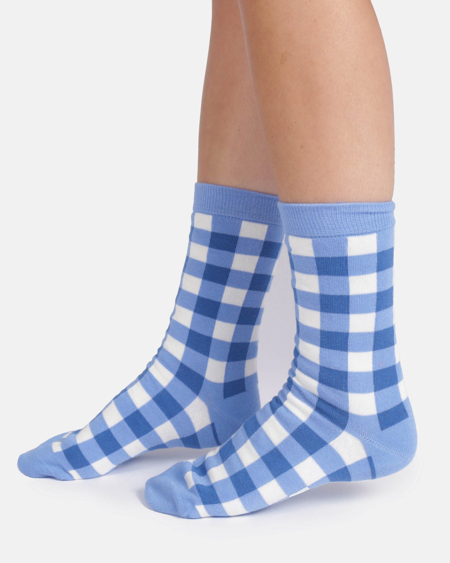 Blue and white checkered socks worn by a person on a light gray background