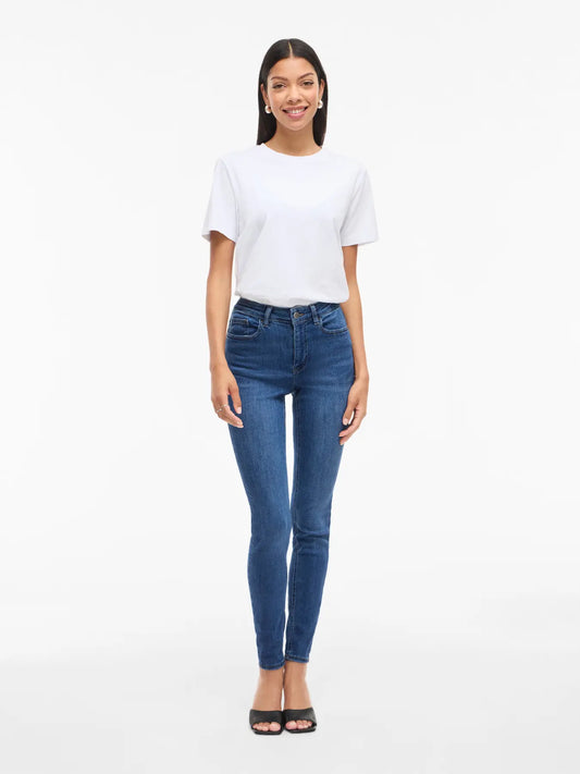 Woman wearing a white t-shirt and blue jeans on a white background