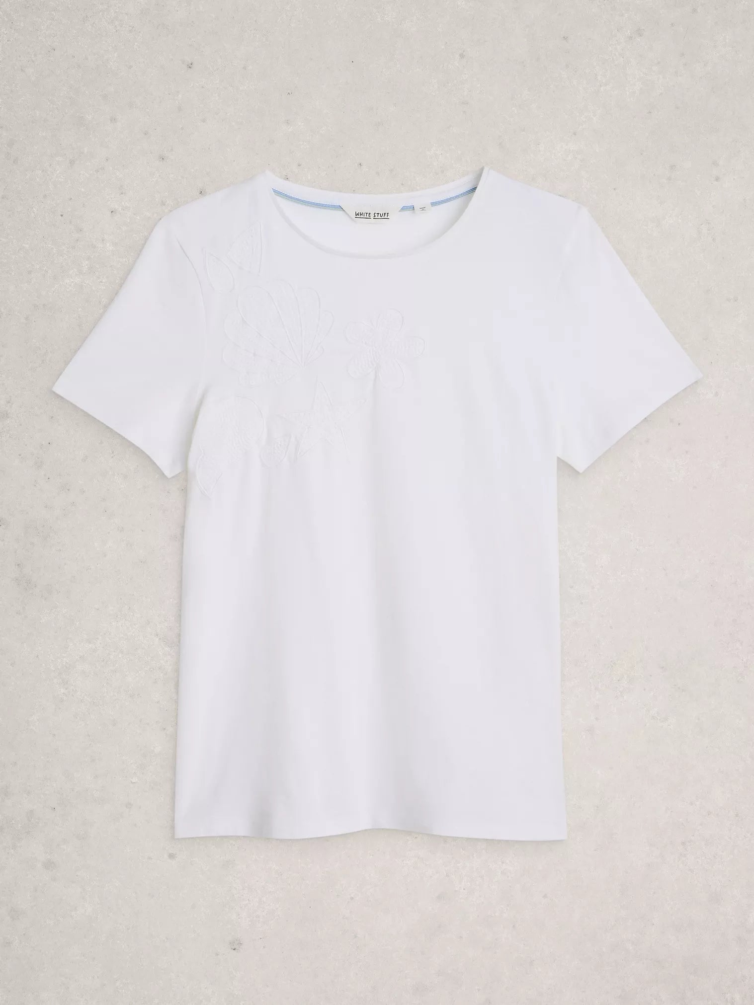 White t-shirt on a light beige background