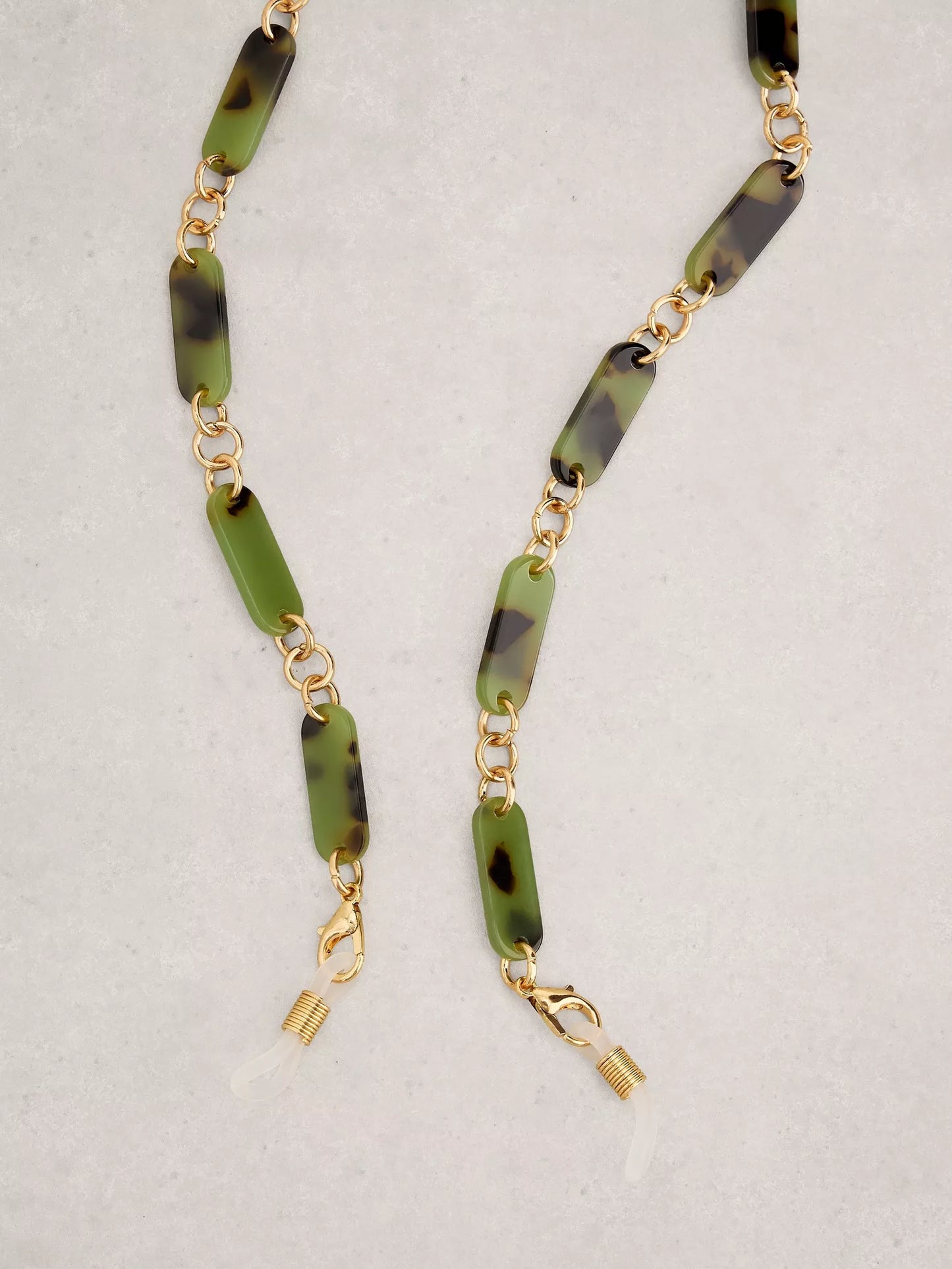 Necklace with green and black beaded chain on a light gray background