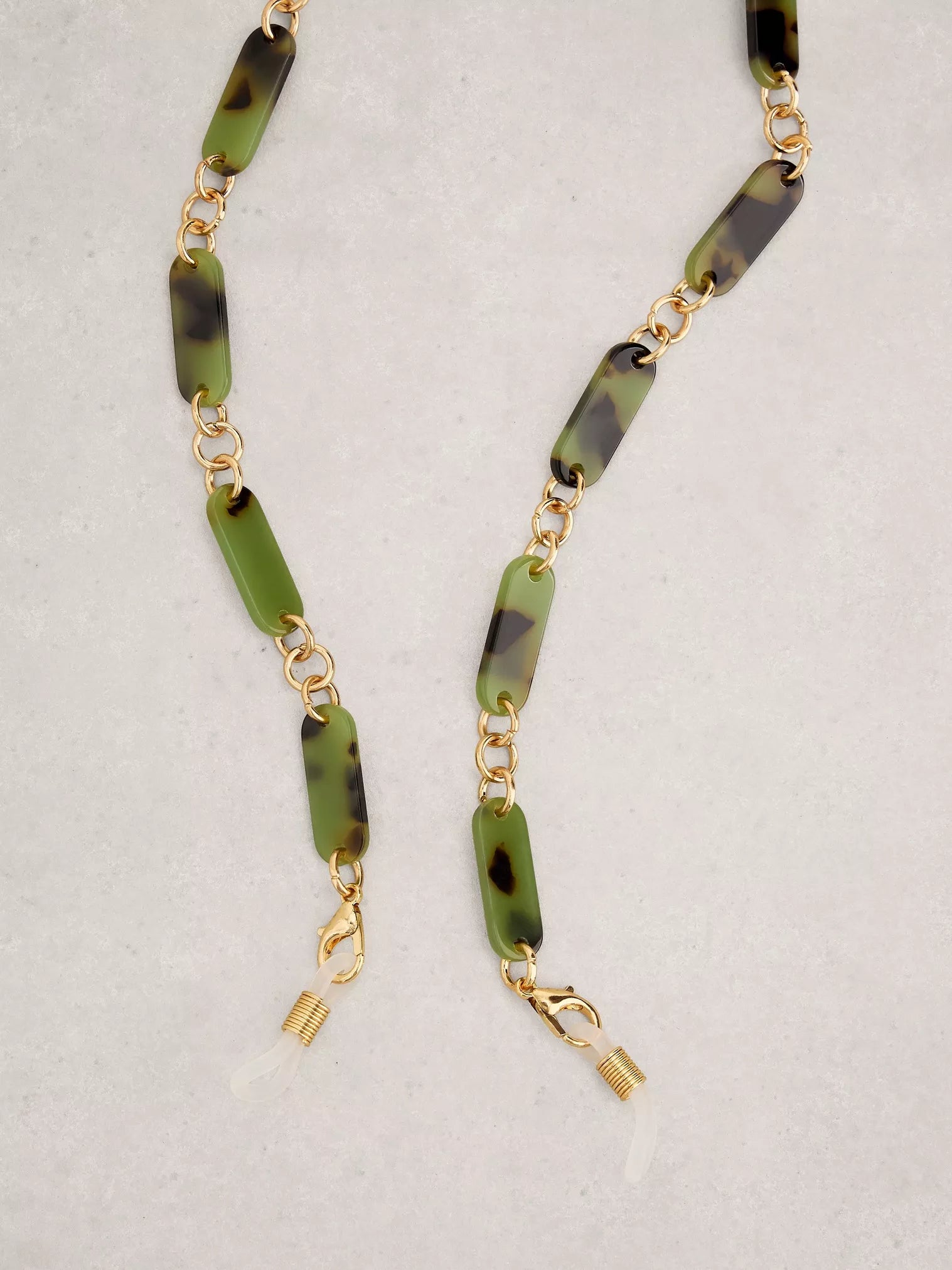 Necklace with green and black beaded chain on a light gray background