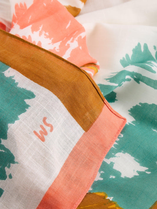 Close-up of a fabric with colorful floral patterns and a brand logo.