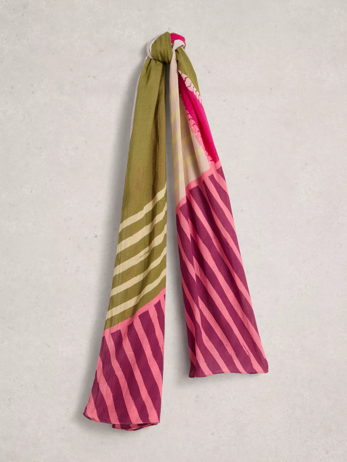 Striped scarf with pink, green, and white pattern on a light gray background