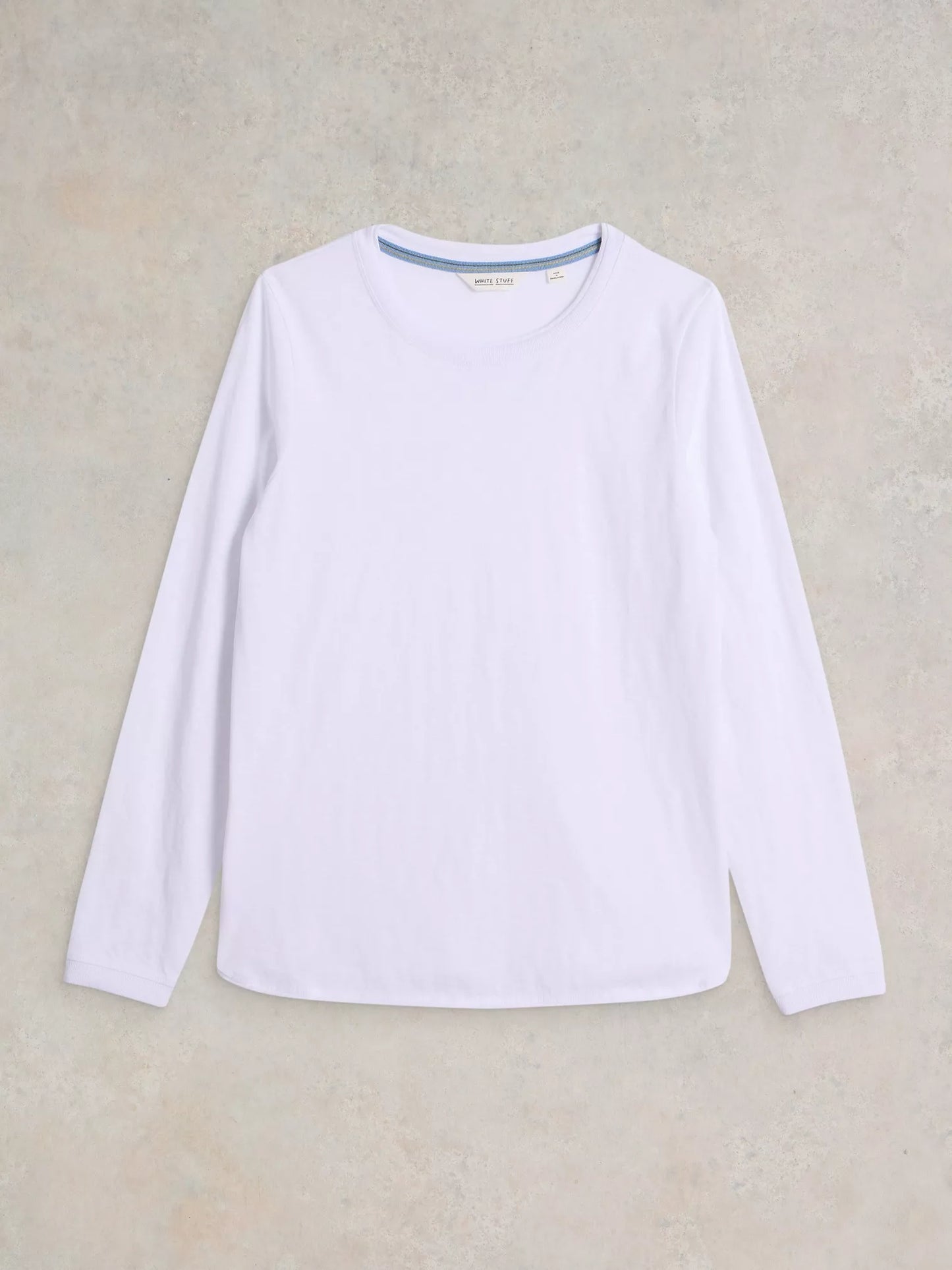 White long-sleeve shirt on a beige background