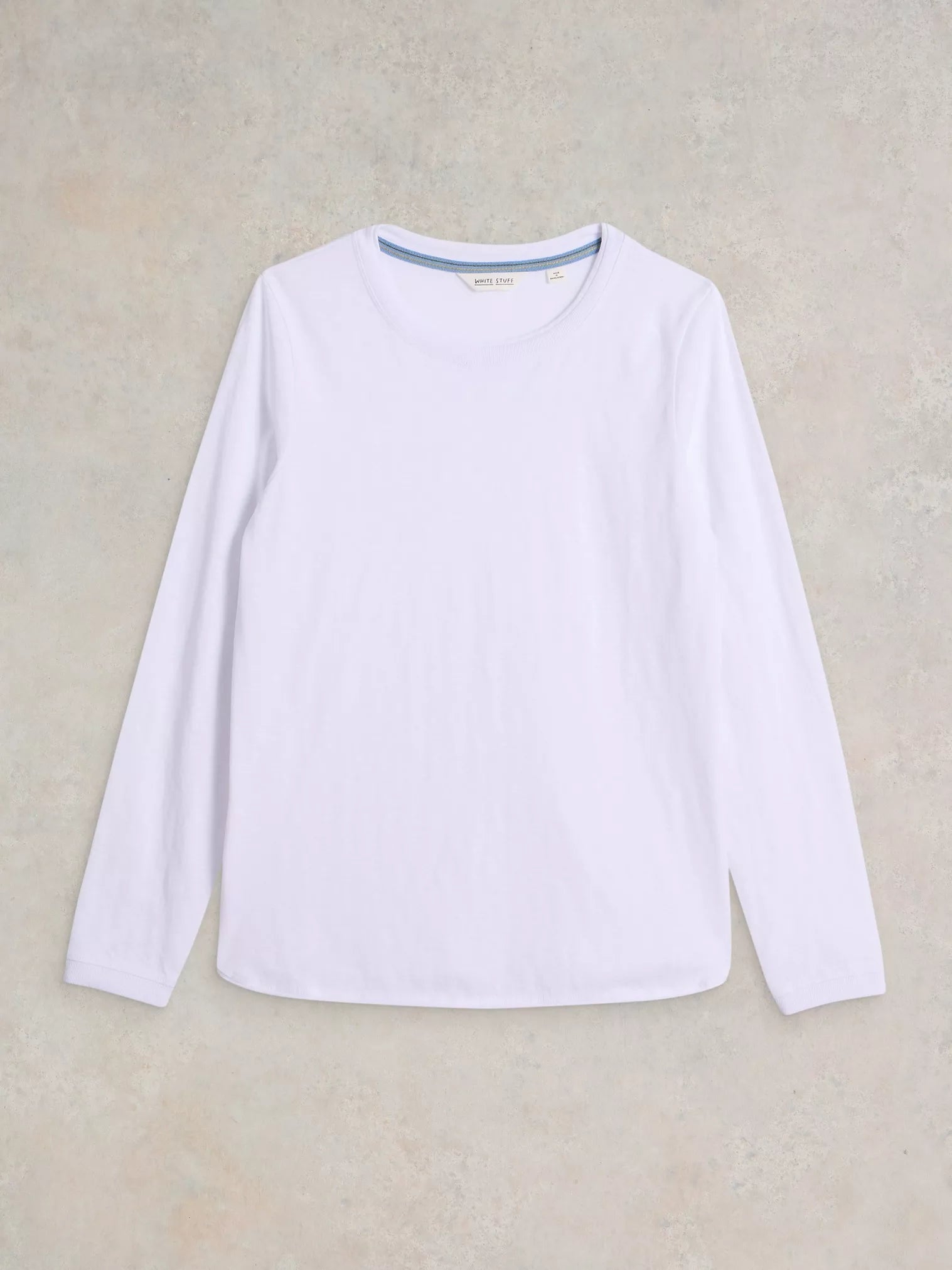 White long-sleeve shirt on a beige background