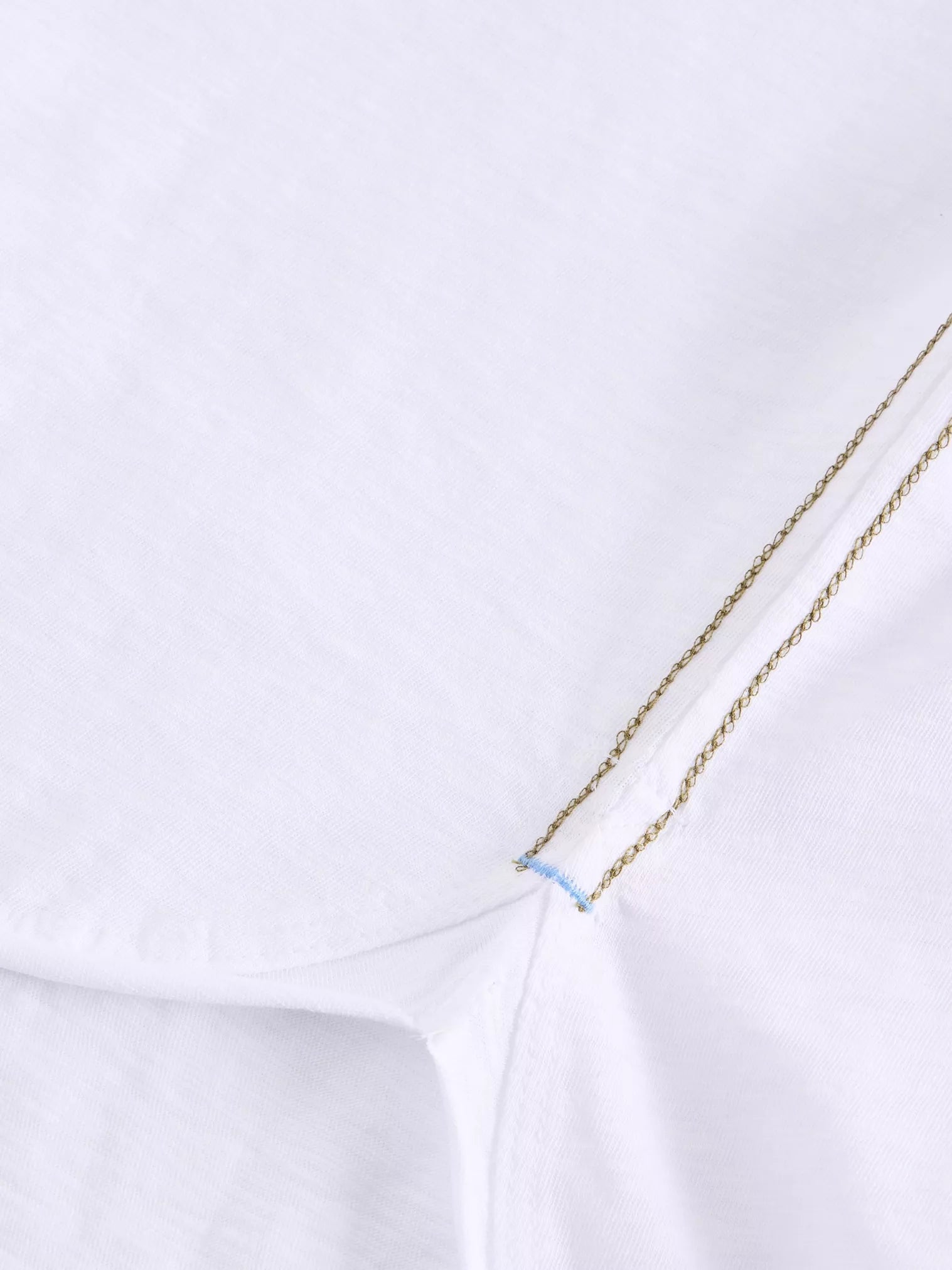 Close-up of a white shirt with khaki green trim 