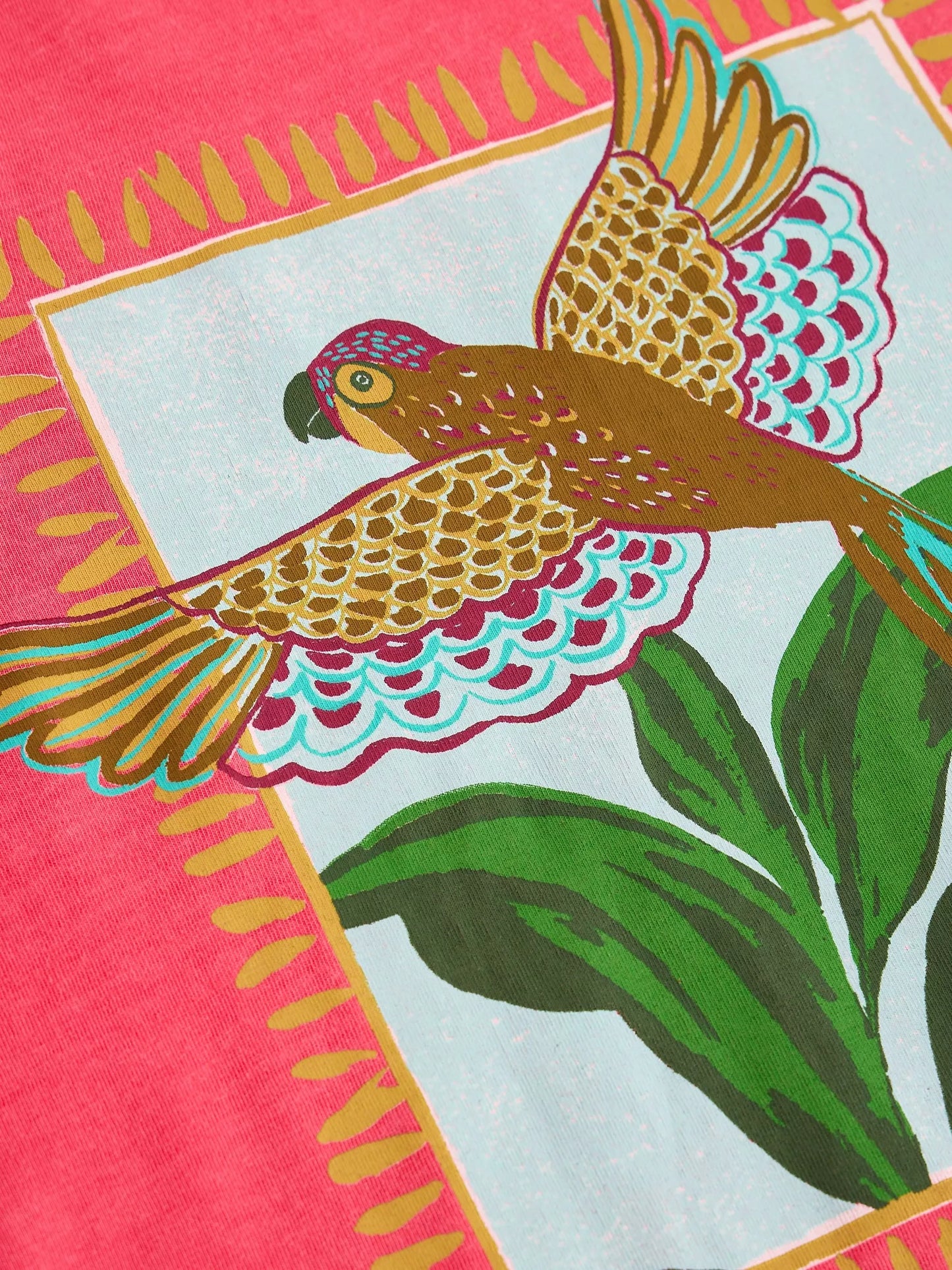 Colorful fabric with a parrot design on a pink background