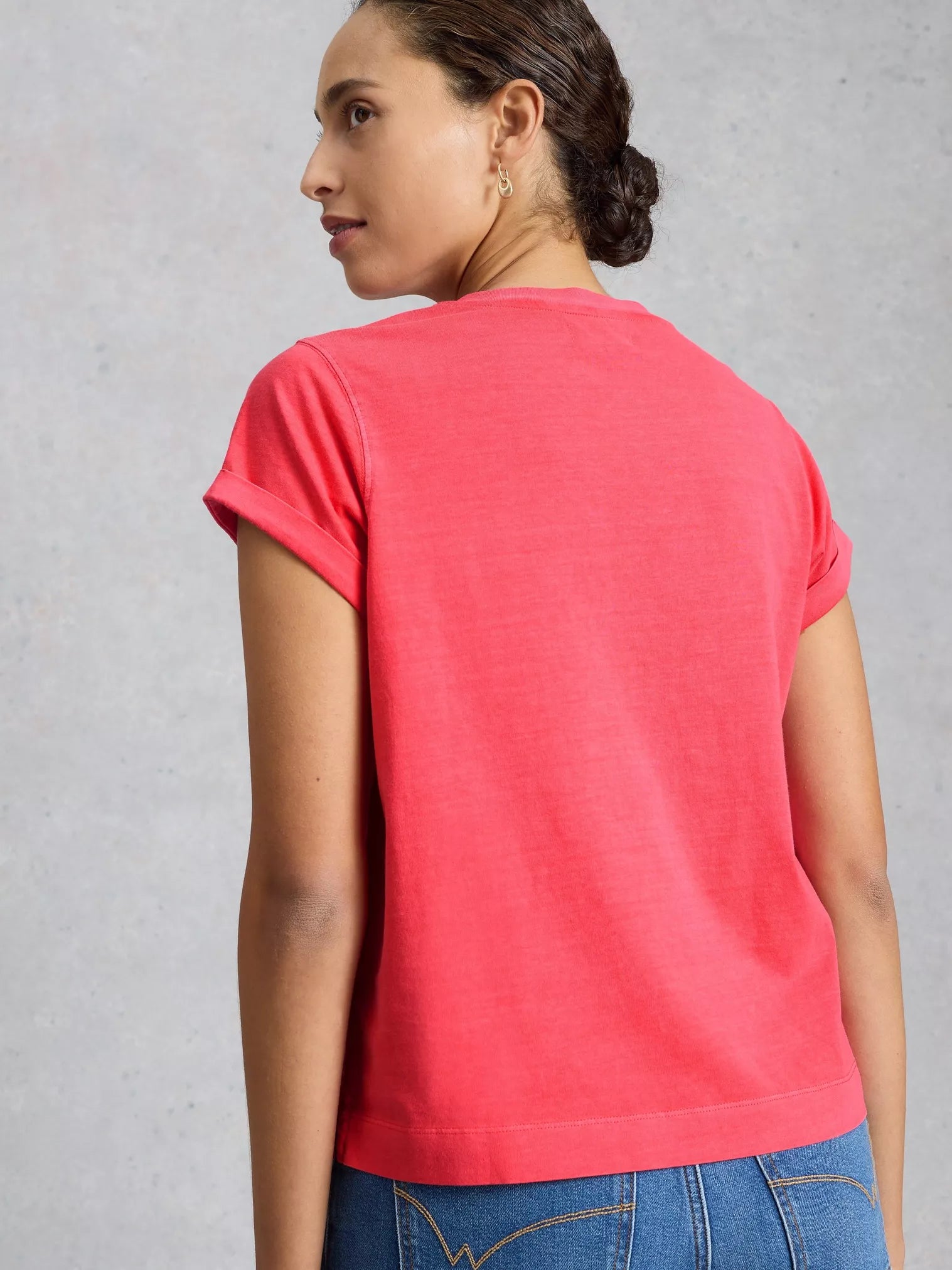 Woman wearing a red t-shirt against a gray background