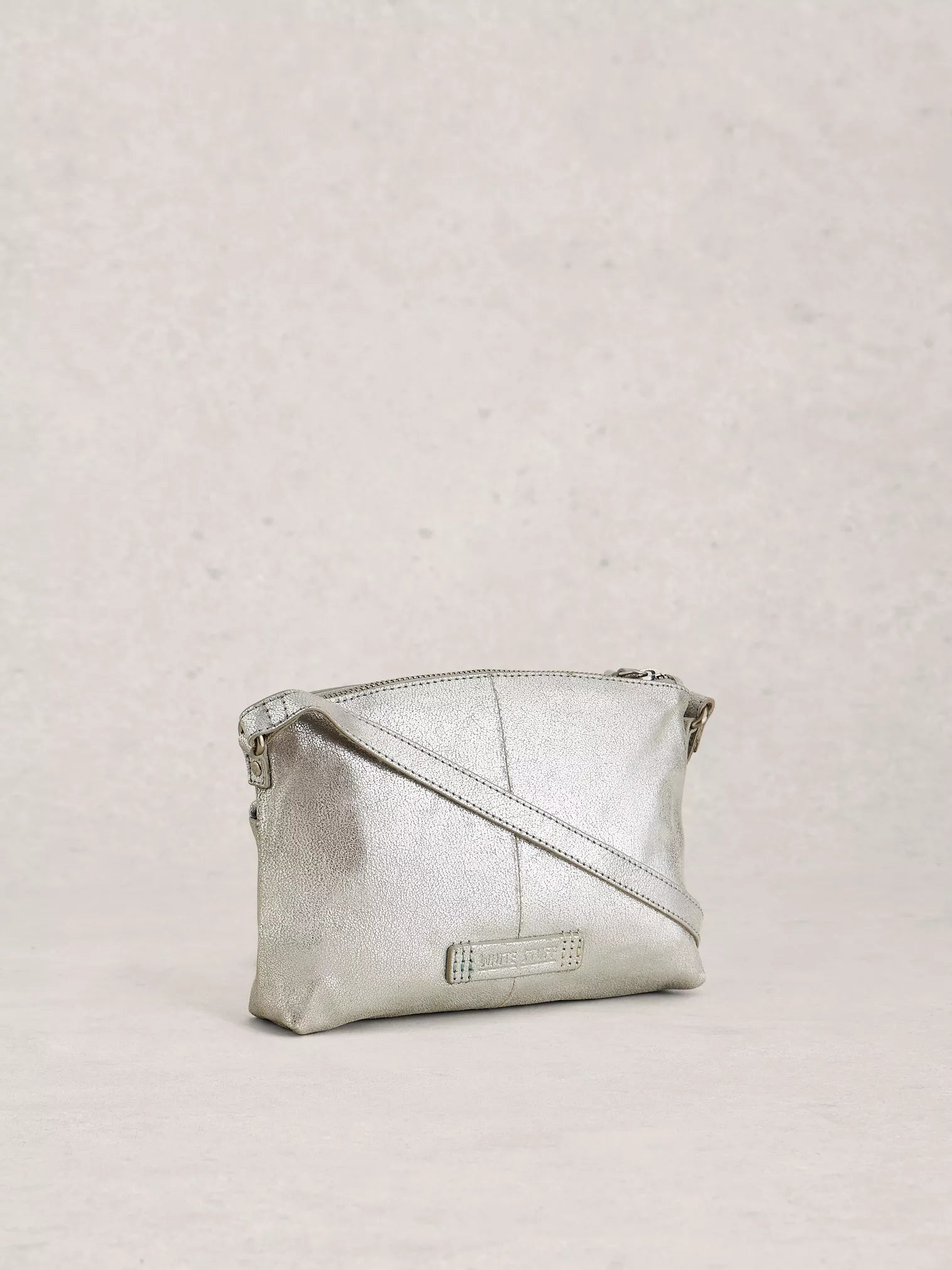 Silver crossbody bag on a light grey background