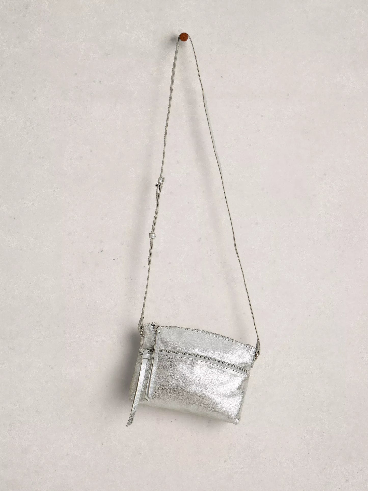 Silver crossbody bag on a light gray background