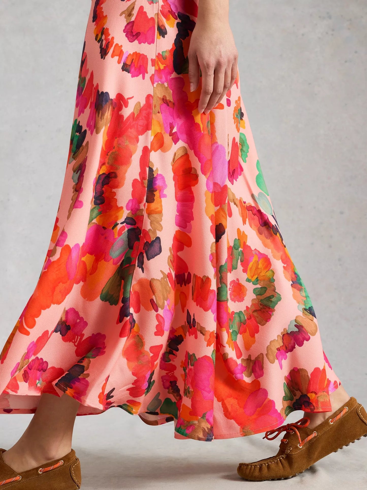 Colorful floral dress with brown shoes on a neutral background