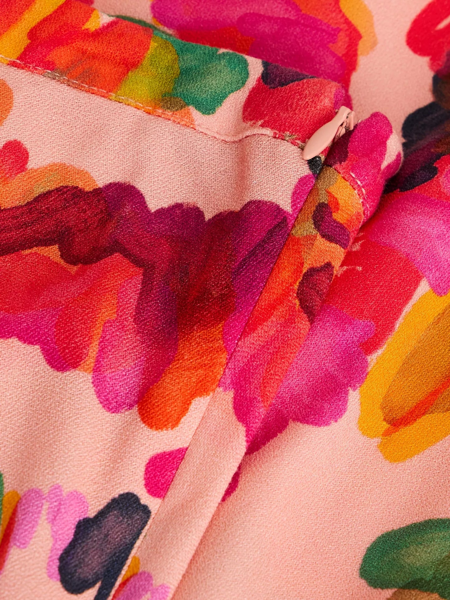 Close-up of colorful fabric with abstract pattern on a pink background