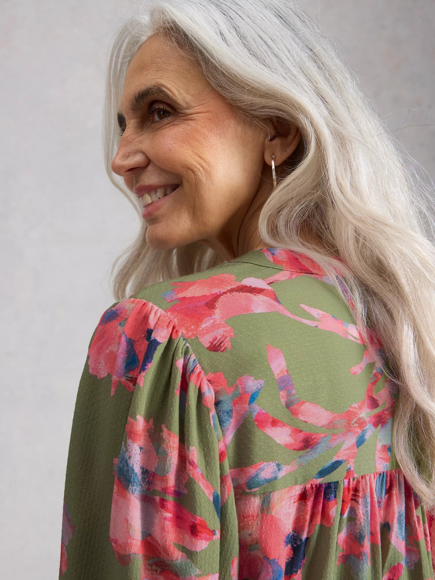 Woman wearing a floral blouse with a plain background