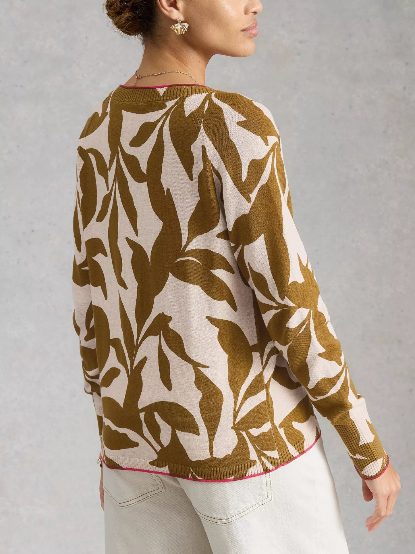 Person wearing a brown and white patterned sweater against a gray background