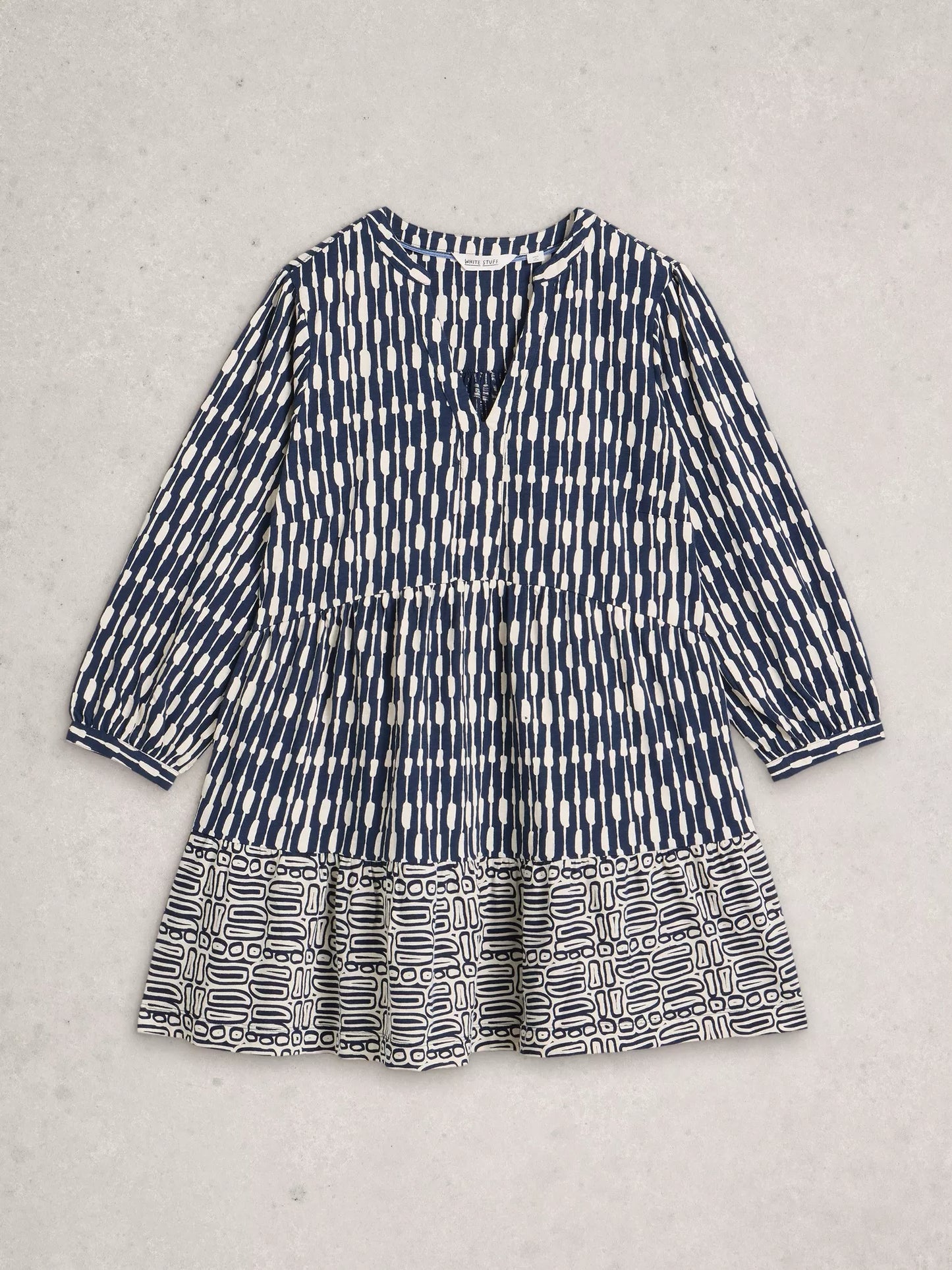 Blue and white patterned tunic on a light gray background