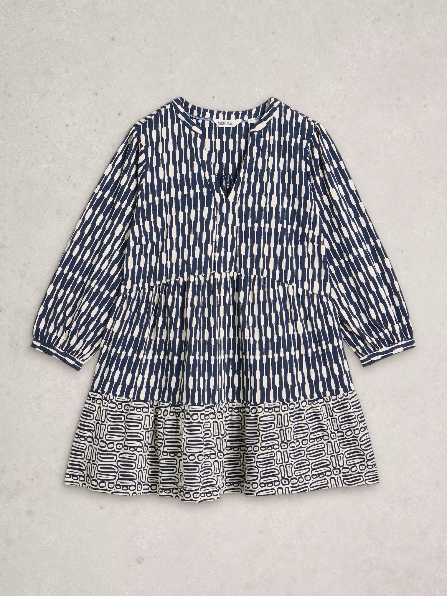 Blue and white patterned tunic on a light gray background