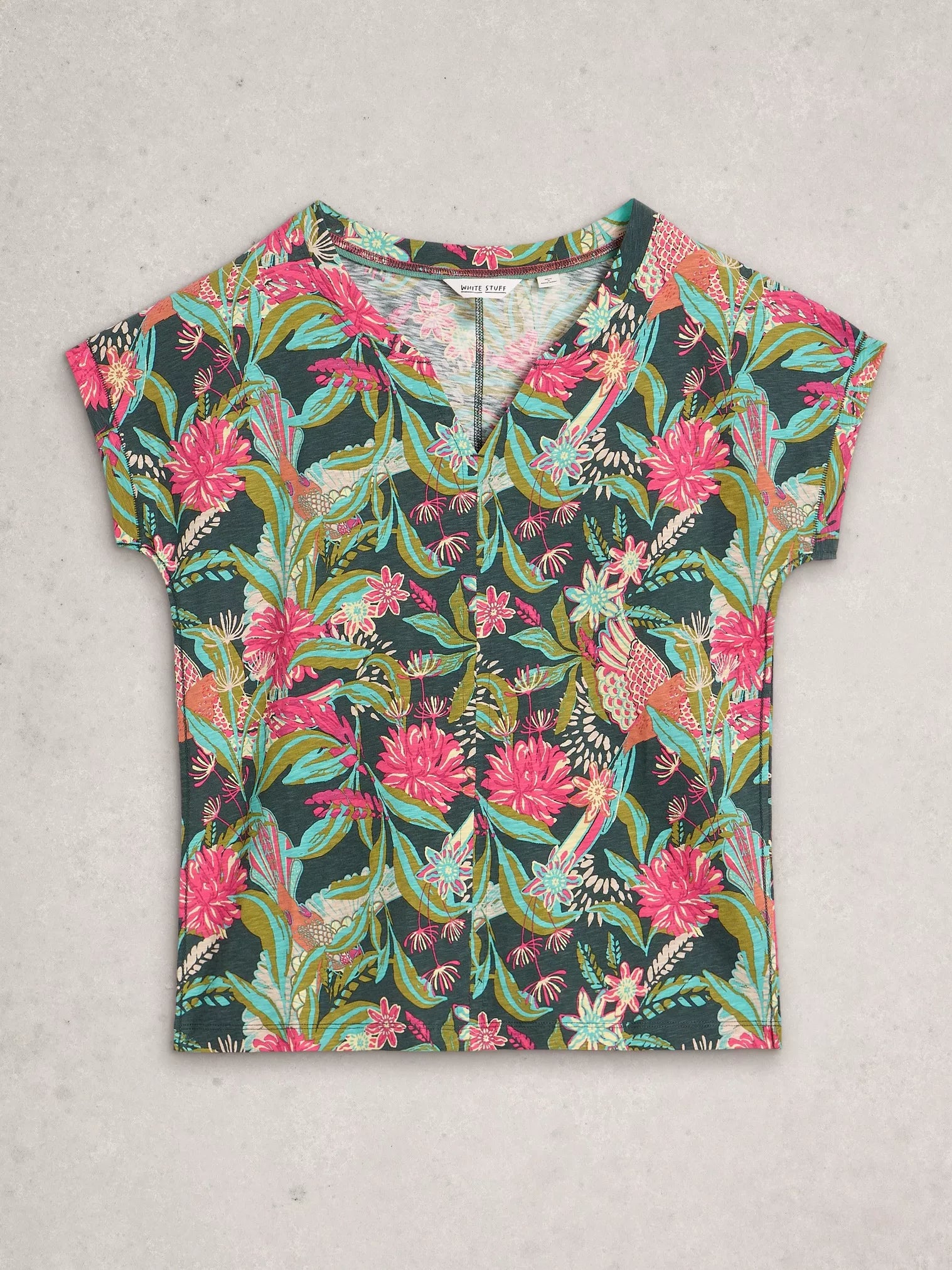 Colorful floral and bird patterned shirt on a light gray background