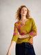 Woman wearing a green and pink floral blouse against a plain background