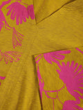 Close-up of yellow fabric with pink floral patterns