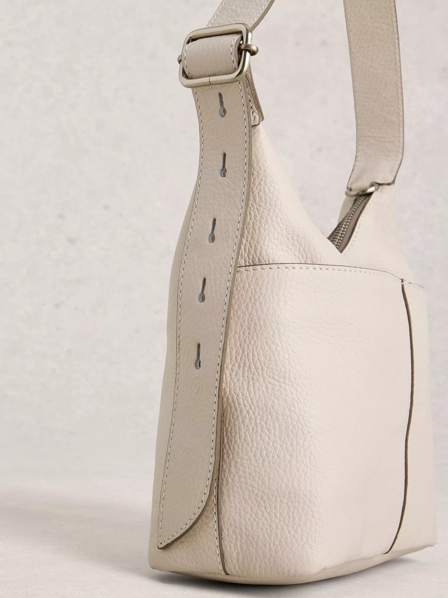 Beige leather shoulder bag on a light gray background