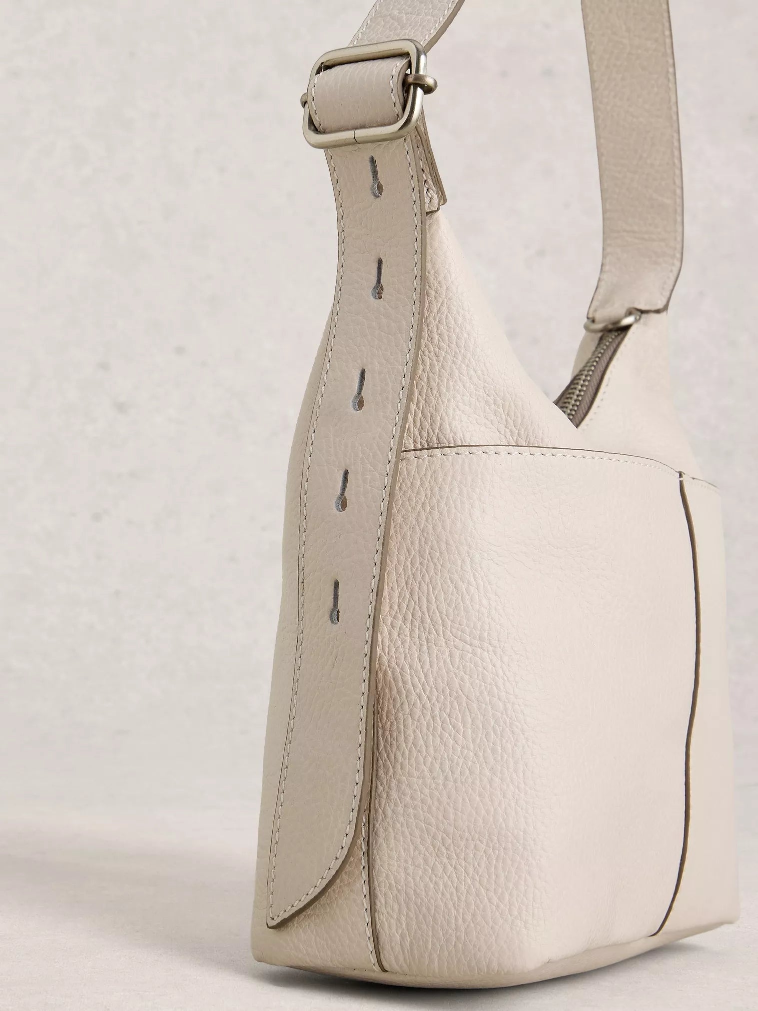 Beige leather shoulder bag on a light gray background