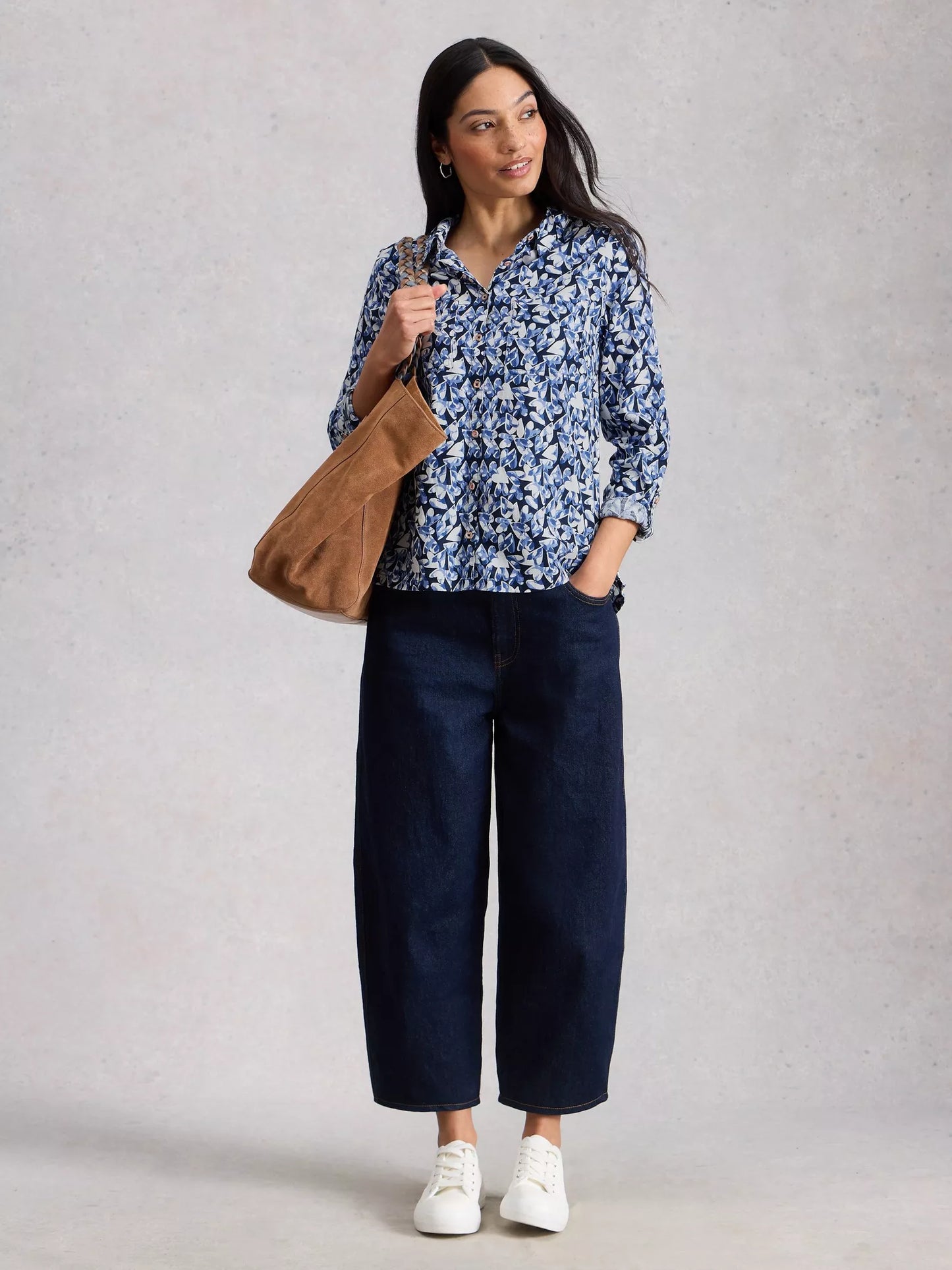 Model in navy shirt with jeans and white pumps