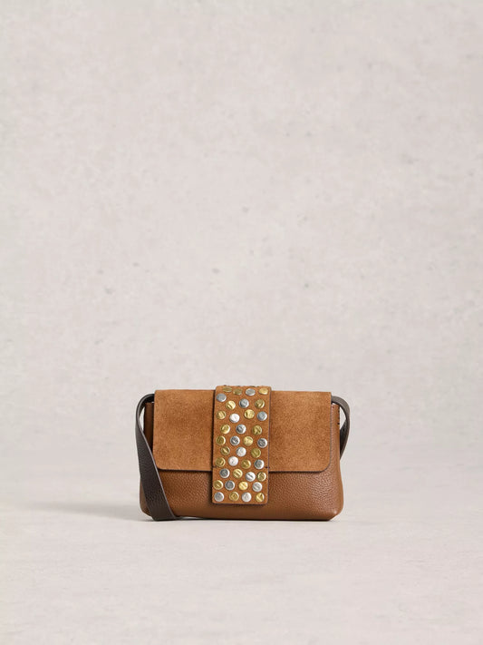 Brown handbag with decorative studs on a light gray background