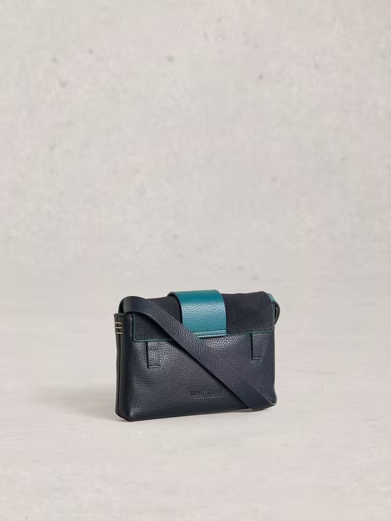 Navy leather crossbody bag with teal accents on a light grey background