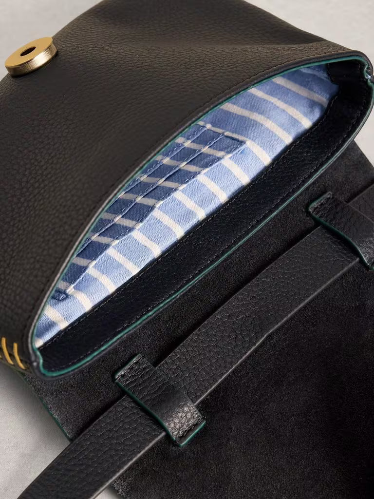 Navy leather bag with blue plaid interior on a light gray background