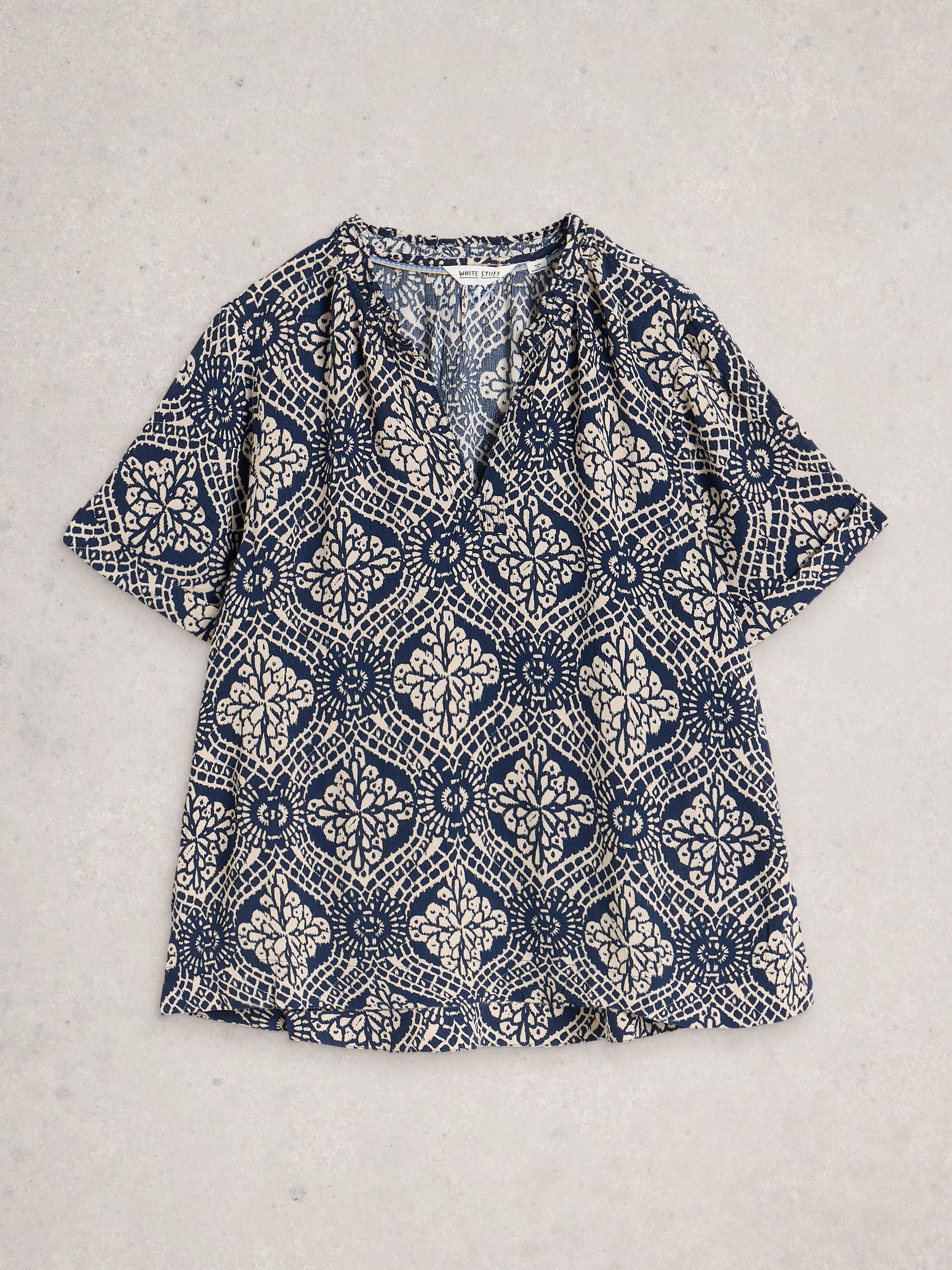 Blue and white patterned shirt on a light gray background