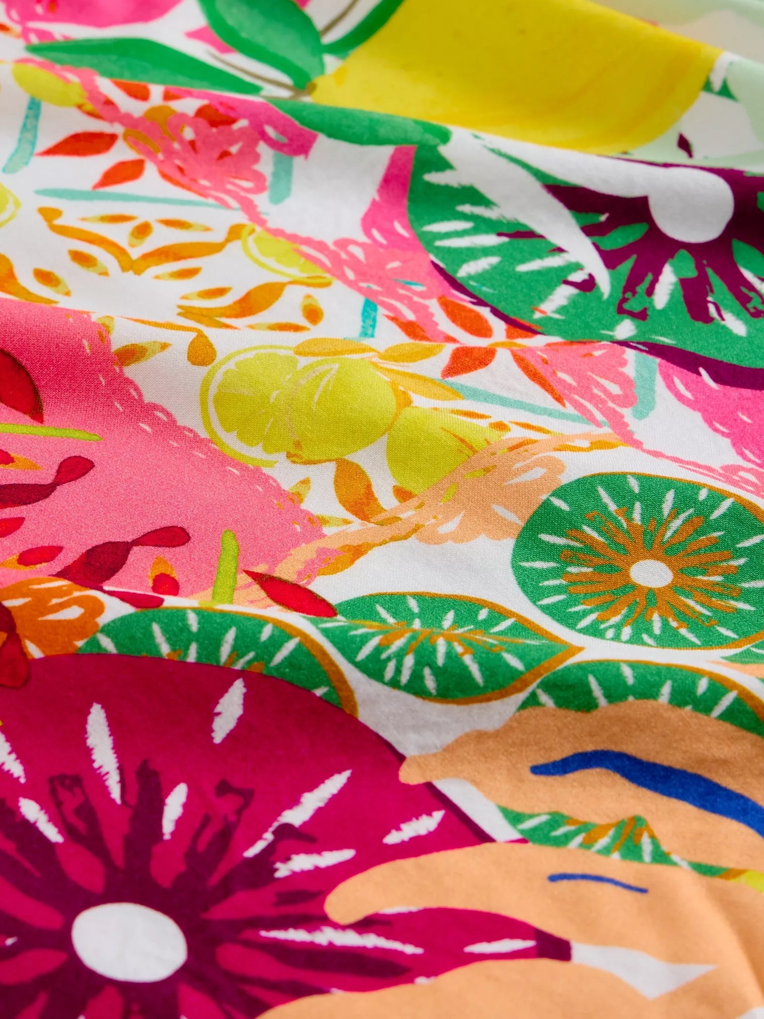 Colorful fabric with a tropical pattern featuring flowers and leaves.