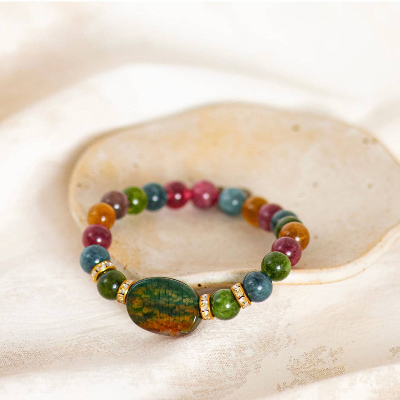 Multicolored beaded bracelet on a shell with a white background